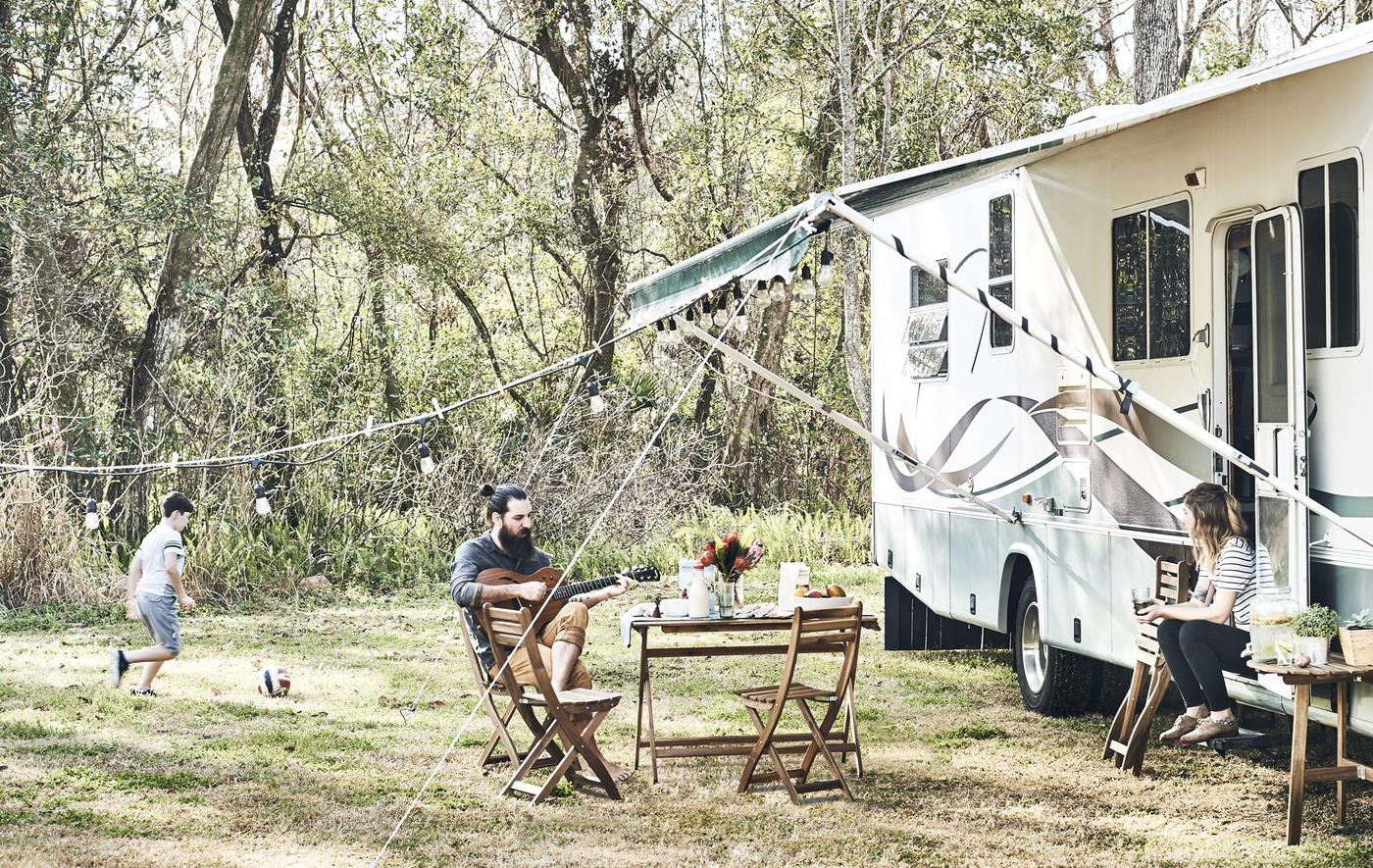 Momento di relax in famiglia davanti a un camper in campagna - IKEA