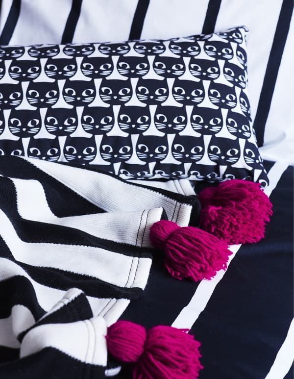 Monochrome textiles with pink tassels.