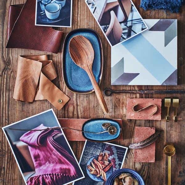 Mood board, která obsahuje modré vzorované misky ENTUSIASM, mosazné háčky HULTARP, dřevěnou lžíci, kostky a kůži.