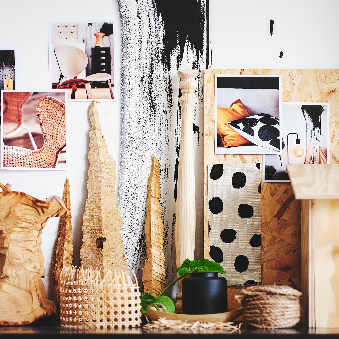 Moodboard colado na parede atrás de objetos feitos em materiais naturais, agrupados de forma criativa.