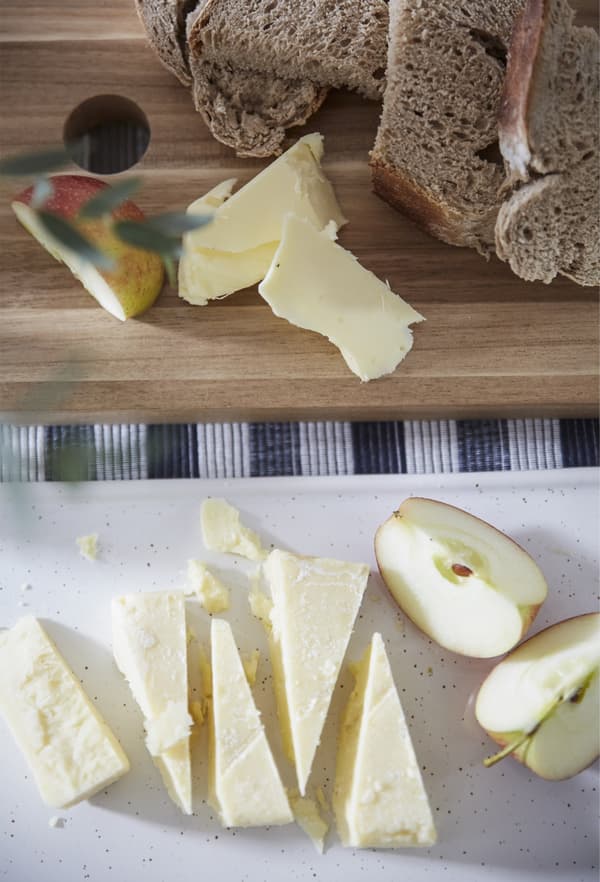 Morceaux de fromage et quartiers de pomme sur une planche en bois