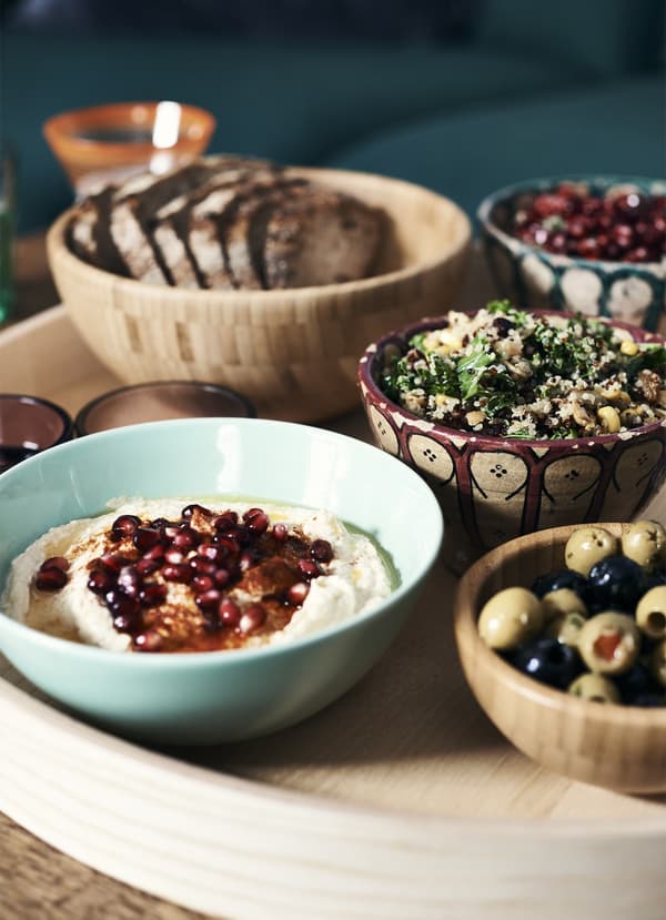 Moroccan-style food served in a variety of small bowls on a wooden tray.