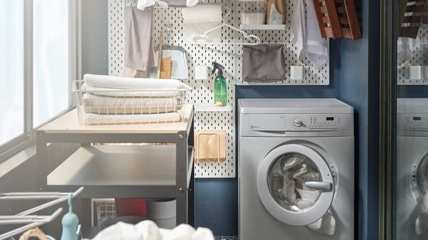 Mosógépből, szárítóból és fali polcból álló, kis erkélyterületen létrehozott mosoda.