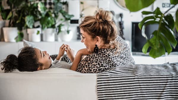 Mother and daughter playing on a sofa 