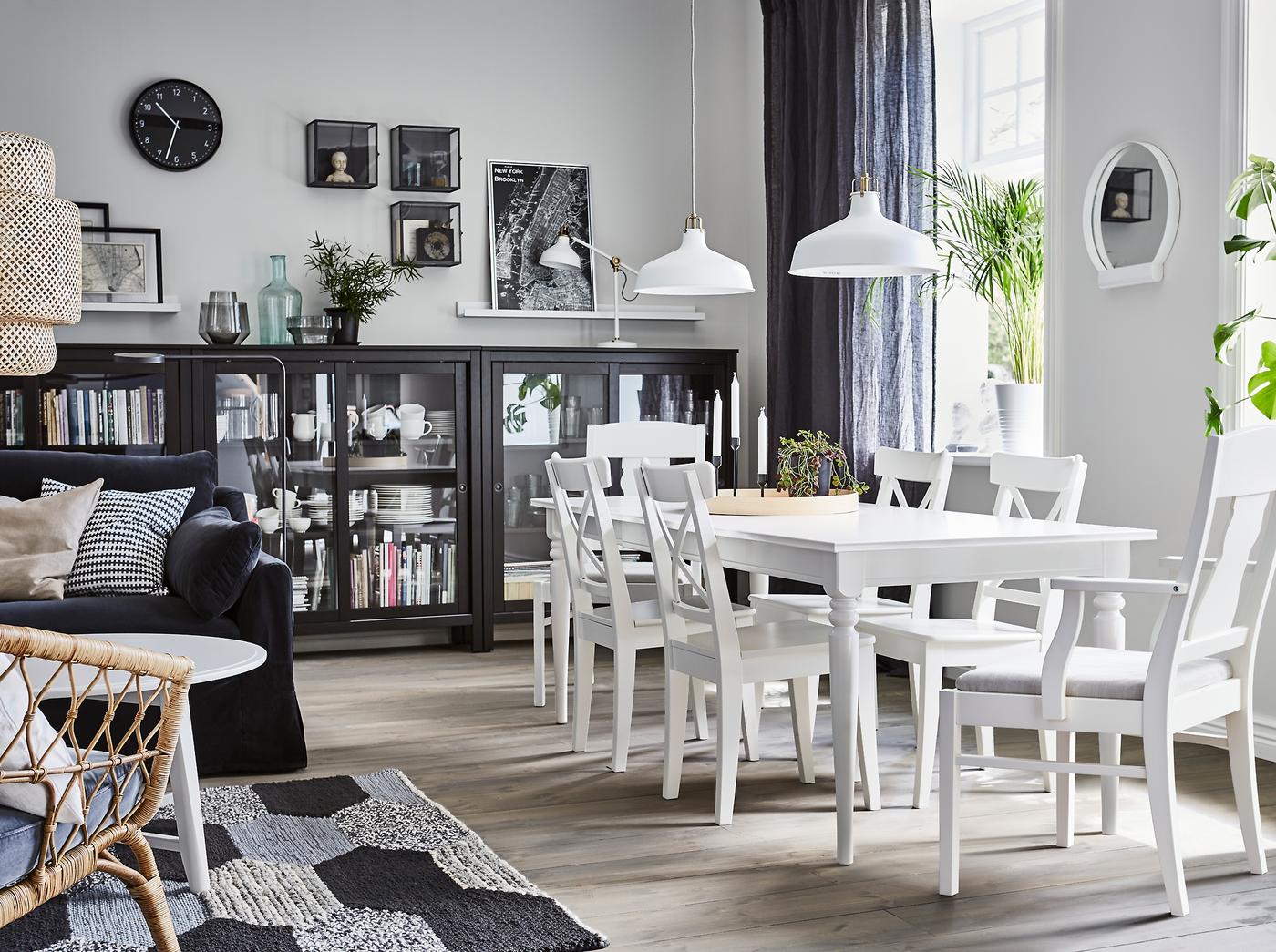 مساحة غرفة طعام ذات طراز تقليدي بجوار غرفة الجلوس بها طاولة طعام قابلة للتمديد INGATORP وكراسي INGATORP بمقاعد ناعمة مبطنة. خزانة HEMNES بباب زجاجي ذات لون أسود توفر مساحة لتخزين أواني الطعام.