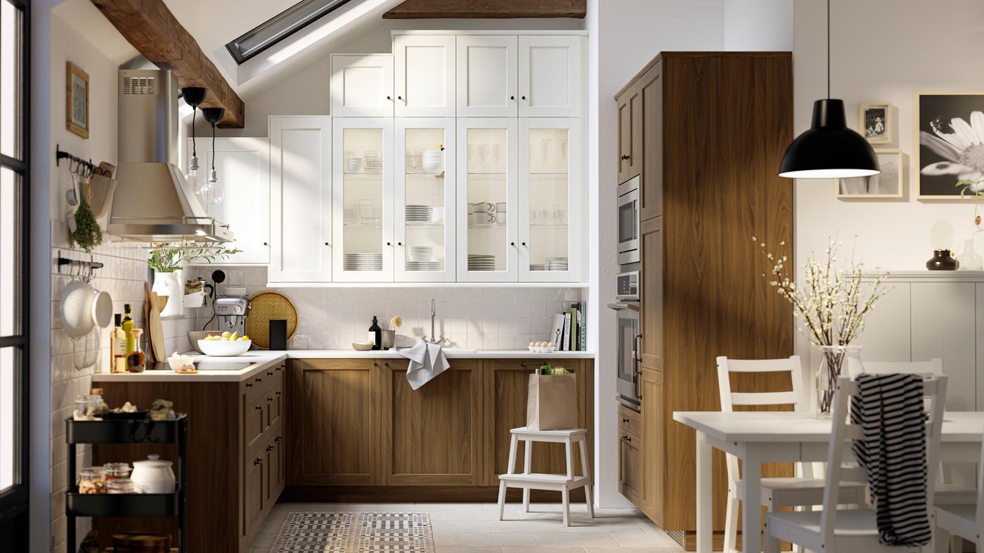 مطبخ بأبواب بلمسات الخشب الأبيض وأبواب زجاجية وأبواب ENKÖPING بتأثير خشب الجوز البني وواجهات أدراج