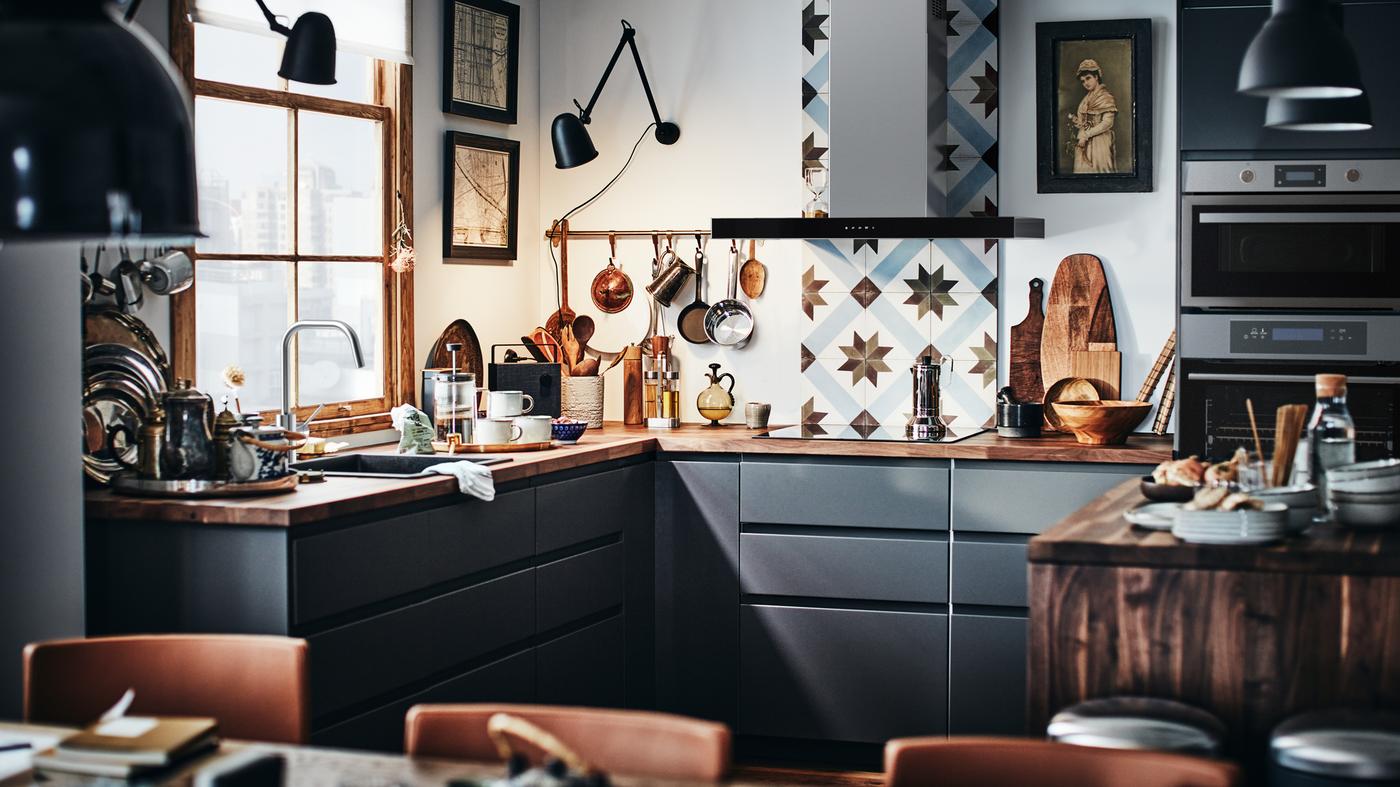 مطبخ METOD عصري بواجهات باللون الرمادي الغامق وسطح عمل خشبي مع لوح حائط مطبخ مبلط.