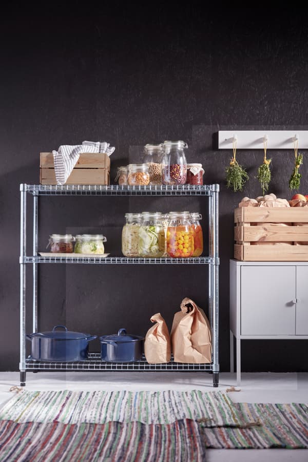Mueble OMAR puesto en la cocina con muchas especies en frascos transparentes y junto a un mueble blanco de cocina.