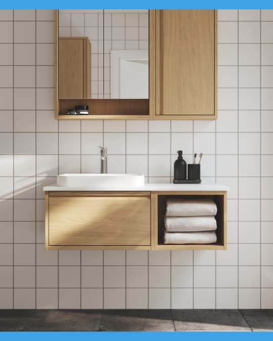Muebles de baño flotantes efecto madera en un baño con cerámicas blancas.