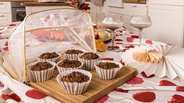 Muffin ai formaggi svedesi in pirottini colorati sopra un vassoio e una tovaglia con decorazioni e bicchier i- IKEA