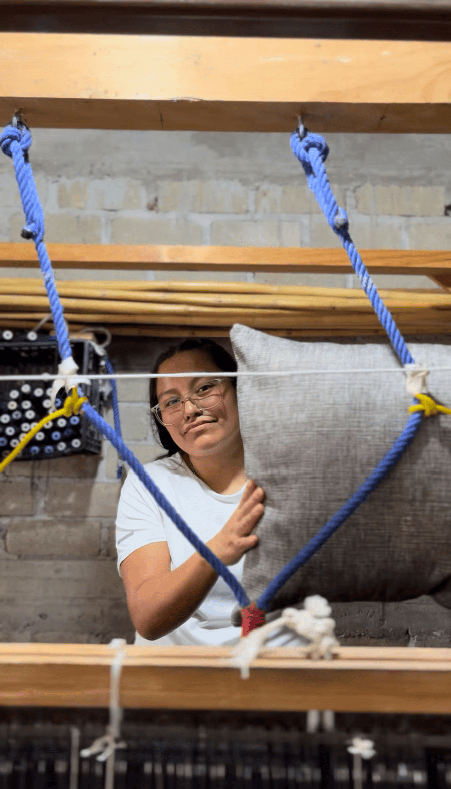 mujer artesana trabajamdo en cojin de tela reciclada