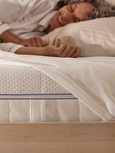 Mujer durmiendo en colchón cómodo