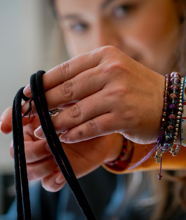 Mujer realizando un llavero tejido a mano para la colección RUNDARE.