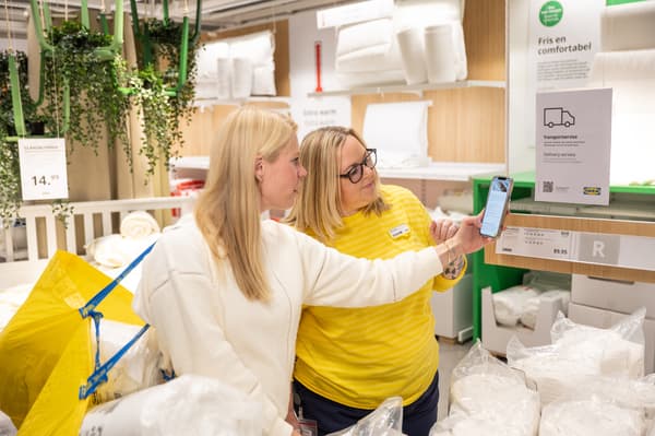 Mujer sosteniendo su telefono en tienda IKEA.