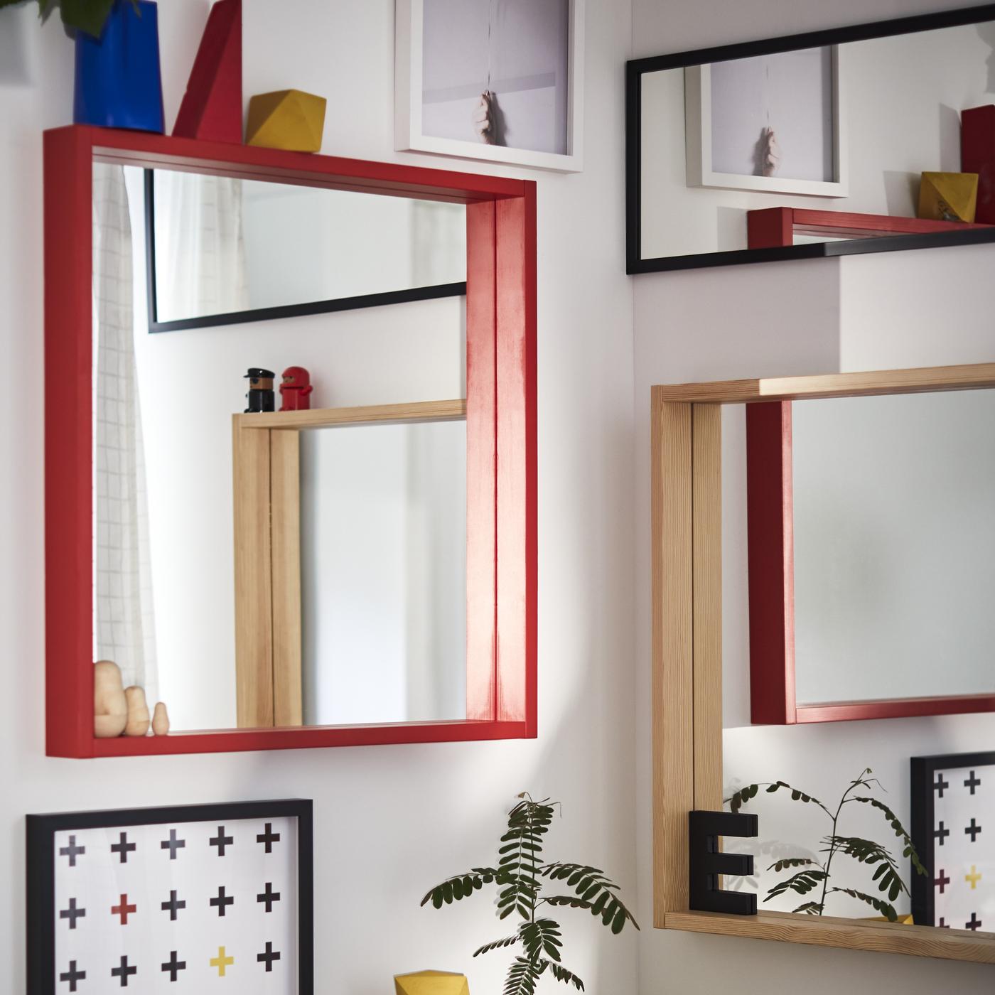 Multiple mirrors and colorful pictures are framed and hanging on the walls.