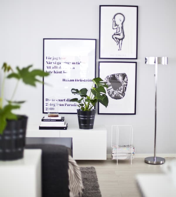 Mur gris clair décoré avec des reproductions en noir et blanc.