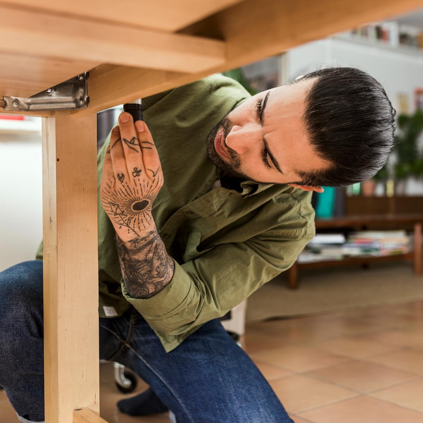 Muškarac šrafi sto.