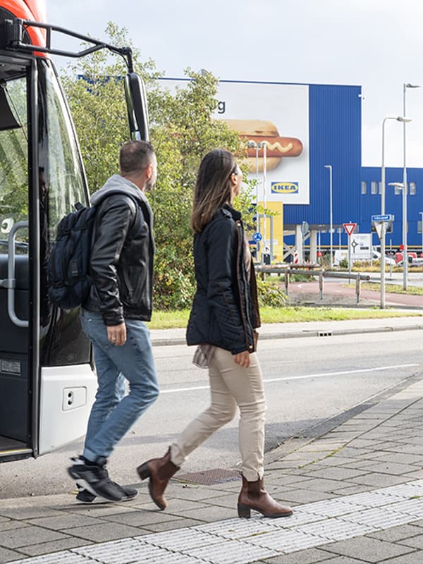 Muž a žena vystupují z autobusu před obchodním domem IKEA