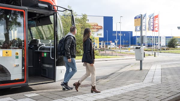 Muž a žena vystupují z autobusu před obchodním domem IKEA