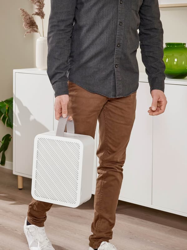 Muž nesie bielu čističku vzduchu UPPÅTVIND.