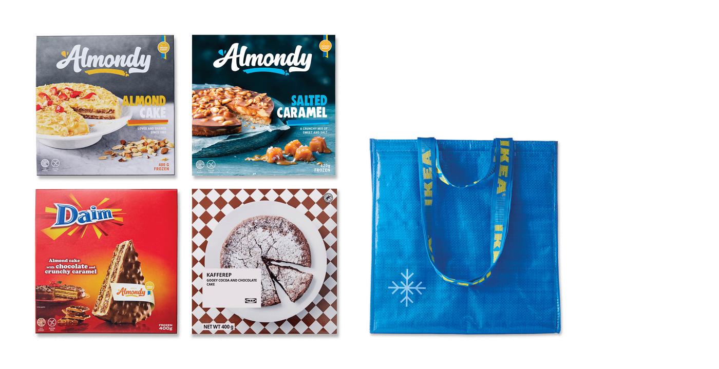 Na obrázku je kolekce mražených dezertů a dortů značky Almondy (včetně variant Daim a Kafferep) a modrá nákupní taška IKEA (FRAKTA) s vločkou, která signalizuje vhodnost pro zmrazené potraviny. 
