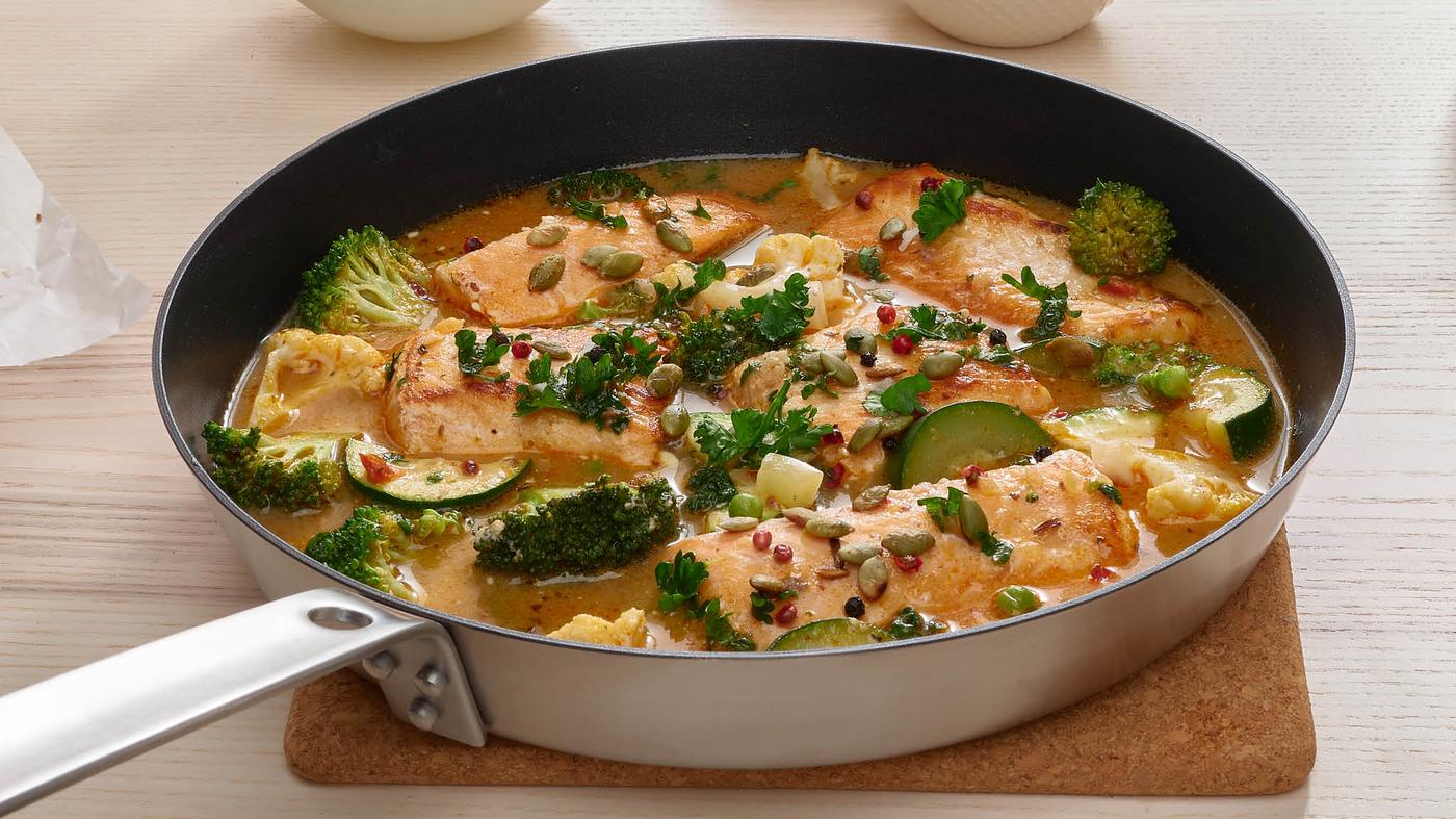 Na podložke pod hrnce HEAT je položená panvica HEMKOMST s lososom SJÖRAPPORT v kokosovej omáčke.