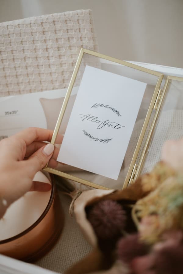 Nachaufnahme eines LERBODA Bilderrahmens aus Glas und goldenem Metall. Darin befindet sich ein Lettering mit der Aufschrift 