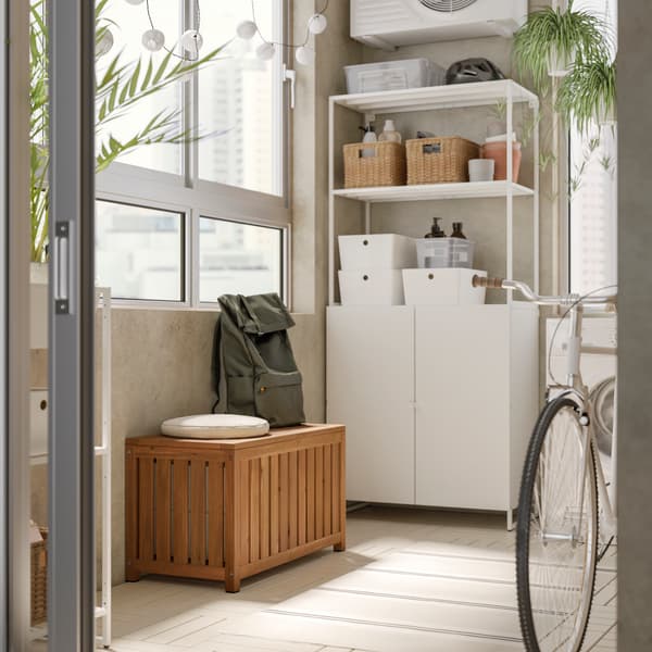 NÄMMARÖ storage stool in laundry service yard area with ENHET laundry storage rack. There is a bag and cushion on the top with bicycle at the side. 