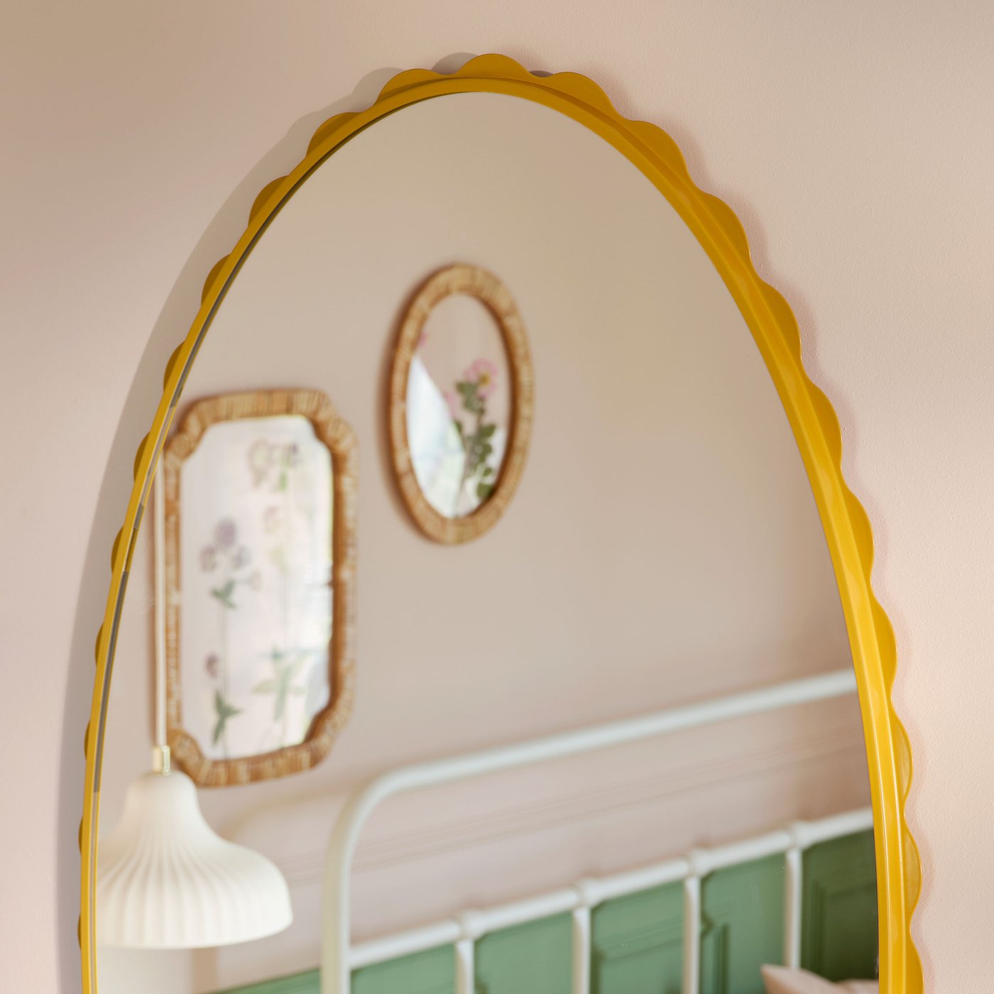 Närbild på DAGGKAPRIFOL oval spegel med gul ram. 