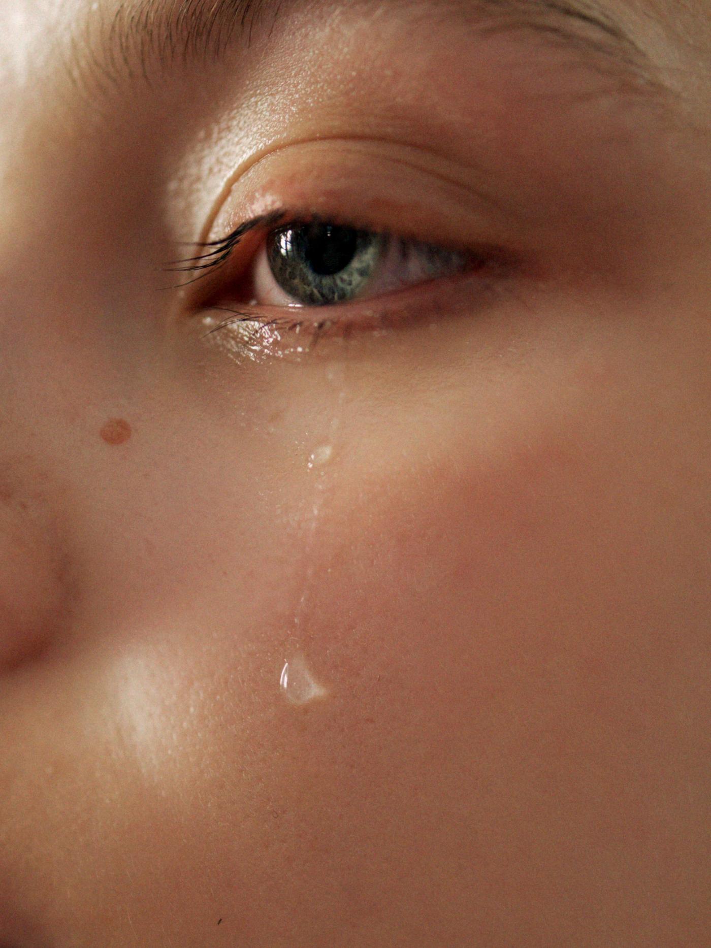 Närbild på en tår som rullar ner för en kind.