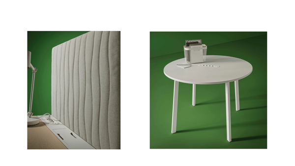 Närbild på ett arbetsbord i vitt och en vit ljuddämpande vägg som är fastsatt på långsidan av ett skrivbord. 