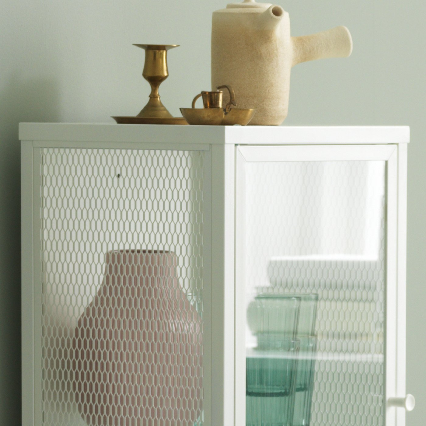 Närbild på ett vitt vitrinskåp i metall.