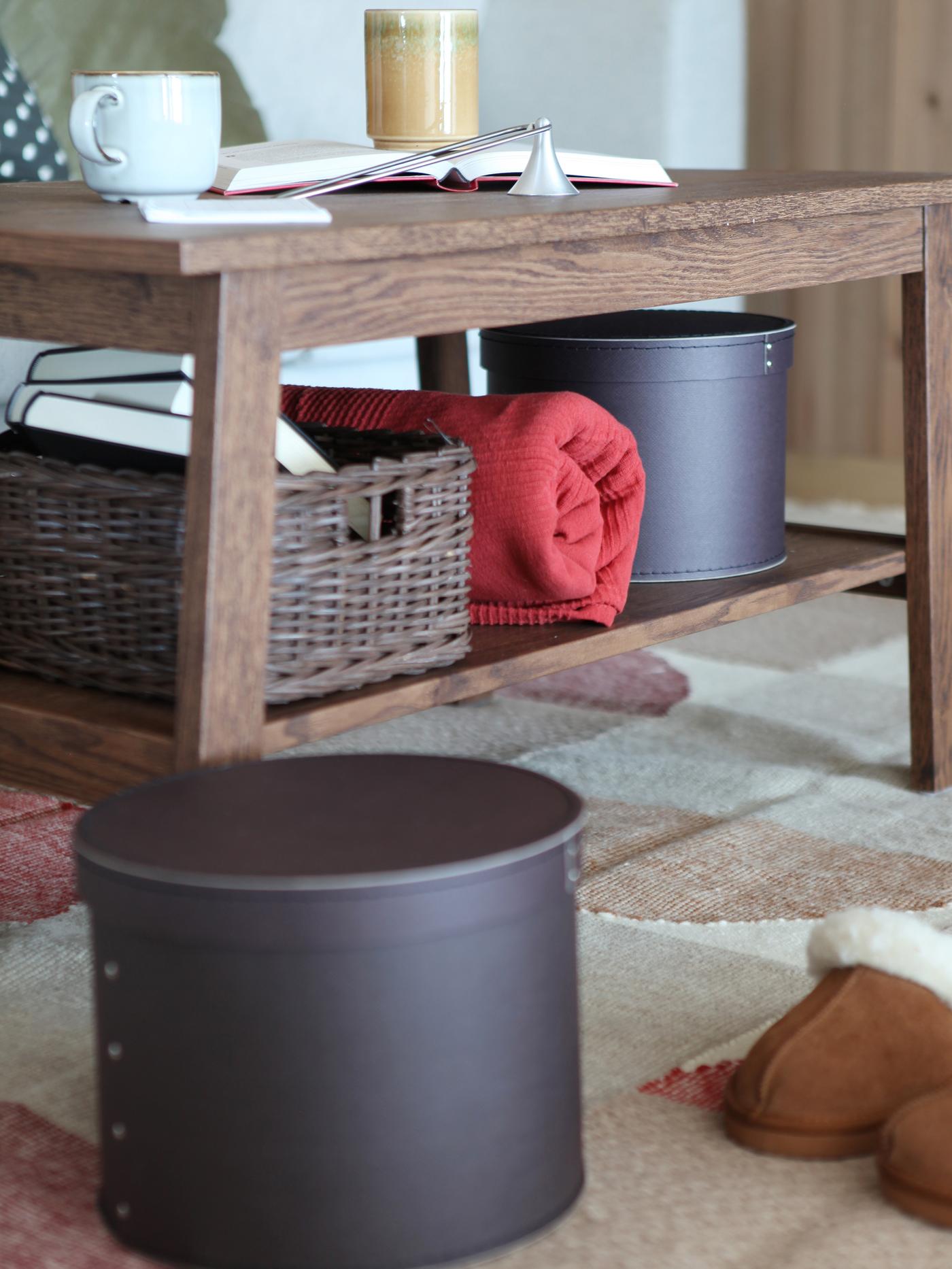 Nærbilde av stuebord i mlrkt tre med oppbevaring.