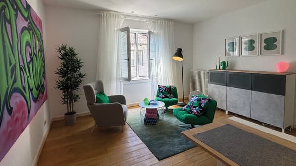 Nahaufnahme des Beratungszimmers für Jugendliche. Auf der linken Seite hängt ein buntes Graffiti an der Wand, in der Mitte des Raumes stehen 3 bequeme Sessel mit bunten Textilien und an der rechten Wand steht ein Highboard mit entsprechender Dekoration.