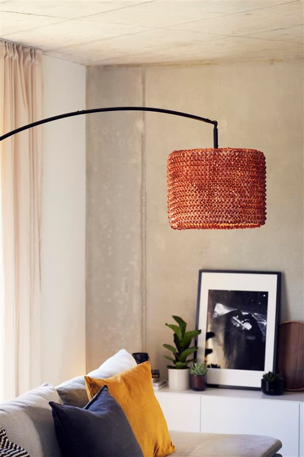 Nahaufnahme einer Ecke im Wohnzimmer mit Sideboard, Sofa und einer grossen, gebogenen Stehlampe