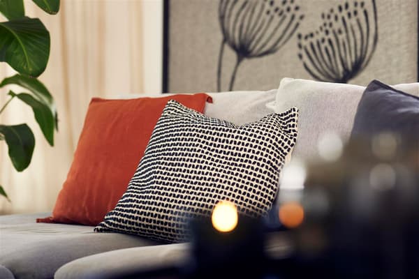 Nahaufnahme von einfarbigen und gemusterten Kissen, die auf einem Sofa liegen