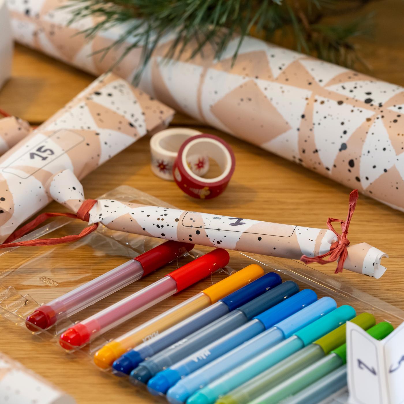 Nahaufnahme von Geschenkpapier und Stiften.