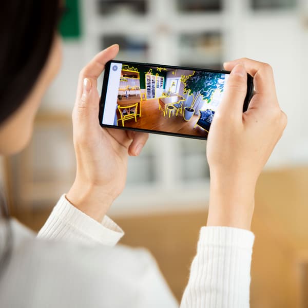 Nainen pitelee käsissään älypuhelinta.