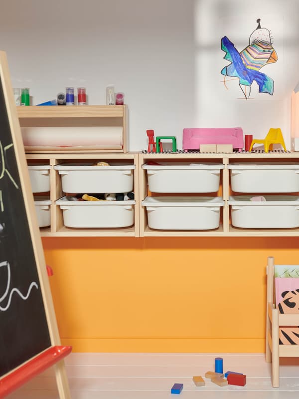 Nástenný úložný diel TROFAST, pred ním maliarsky stojan MÅLA.