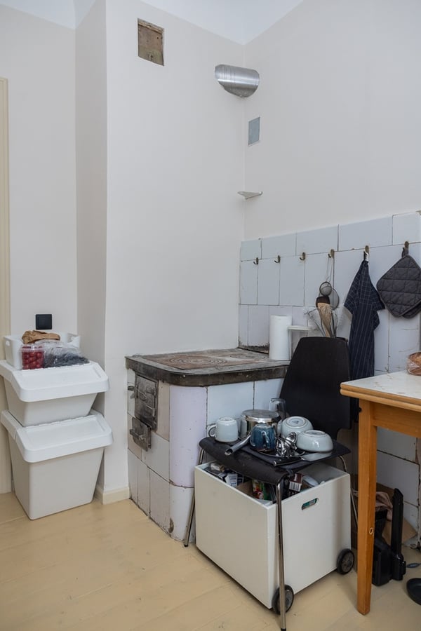 Небольшая комната с дровяной печью, ящиками для хранения и предметами быта.