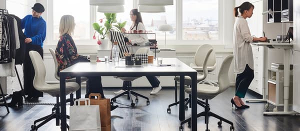 Négy ember egy stílusos és praktikus bútorokkal berendezett irodában.