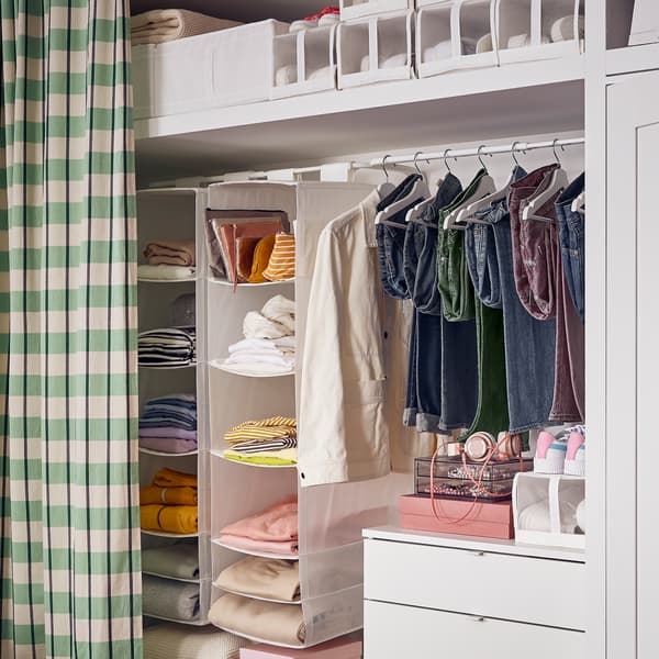 Nelilaatikkoisen VIHALS-lipaston yläpuolelle on ripustettu vaatteita henkariin, ja ripustuskiskosta roikkuu kaksi kuusilokeroista SKUBB-lokerikkoa.