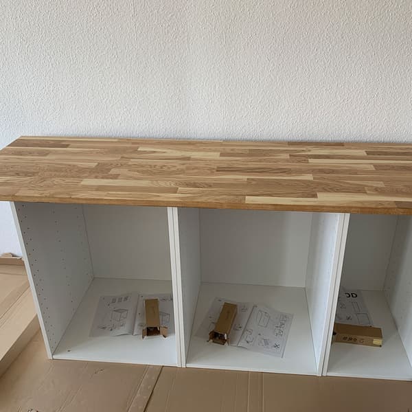 Neue Küche aufbauen: Eine Arbeitsplatte auf halbaufgebauten Schränken.