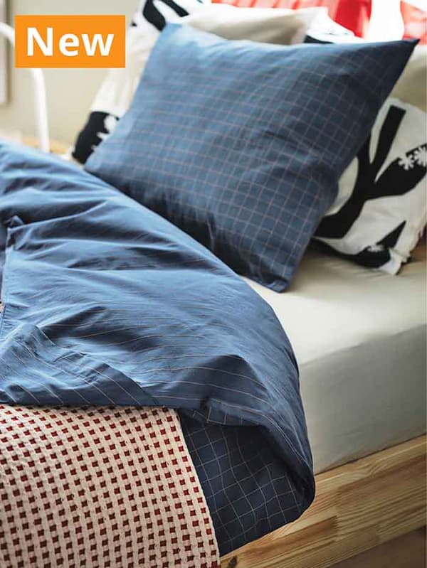 NEW IKEA product. Dark blue checkered DOFTAKLEJA duvet cover and pillowcase on a queen sized bed.