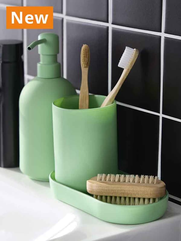 NEW IKEA product. GANSJÖN bathroom set of 3 in light green, filled with two toothbrushes and a brush on top of a white sink.
