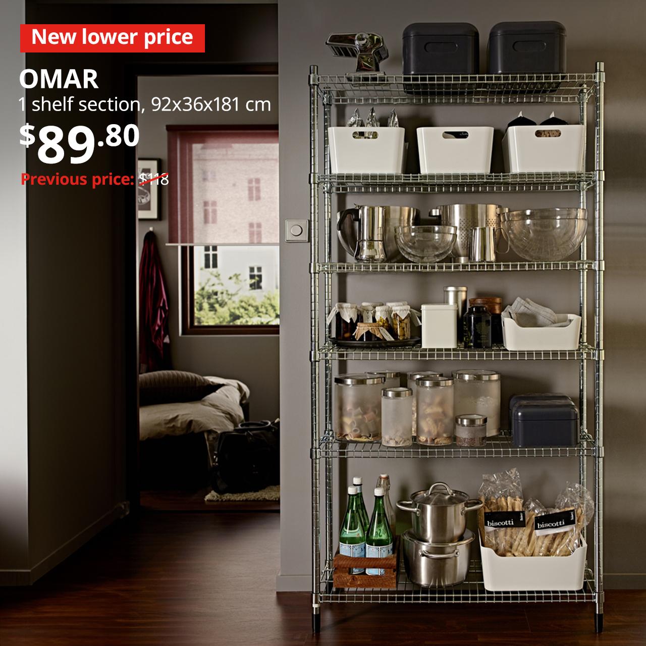 'New lower price' tag in red with white text. A OMAR shelving is placed in a kitchen setting with cookware & bakeware stored on shelvings. Price $89.80. Previous price with red slash: $118.