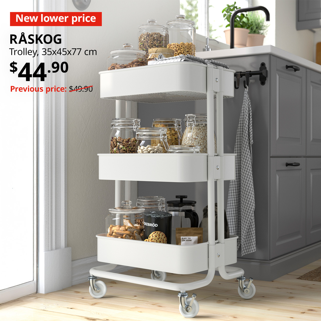 'New lower price' tag in red with white text. A white RÅSKOG trolley is placed in a kitchen setting with cookware & bakeware stored on shelvings. Price $44.90. Previous price with red slash: $49.90.