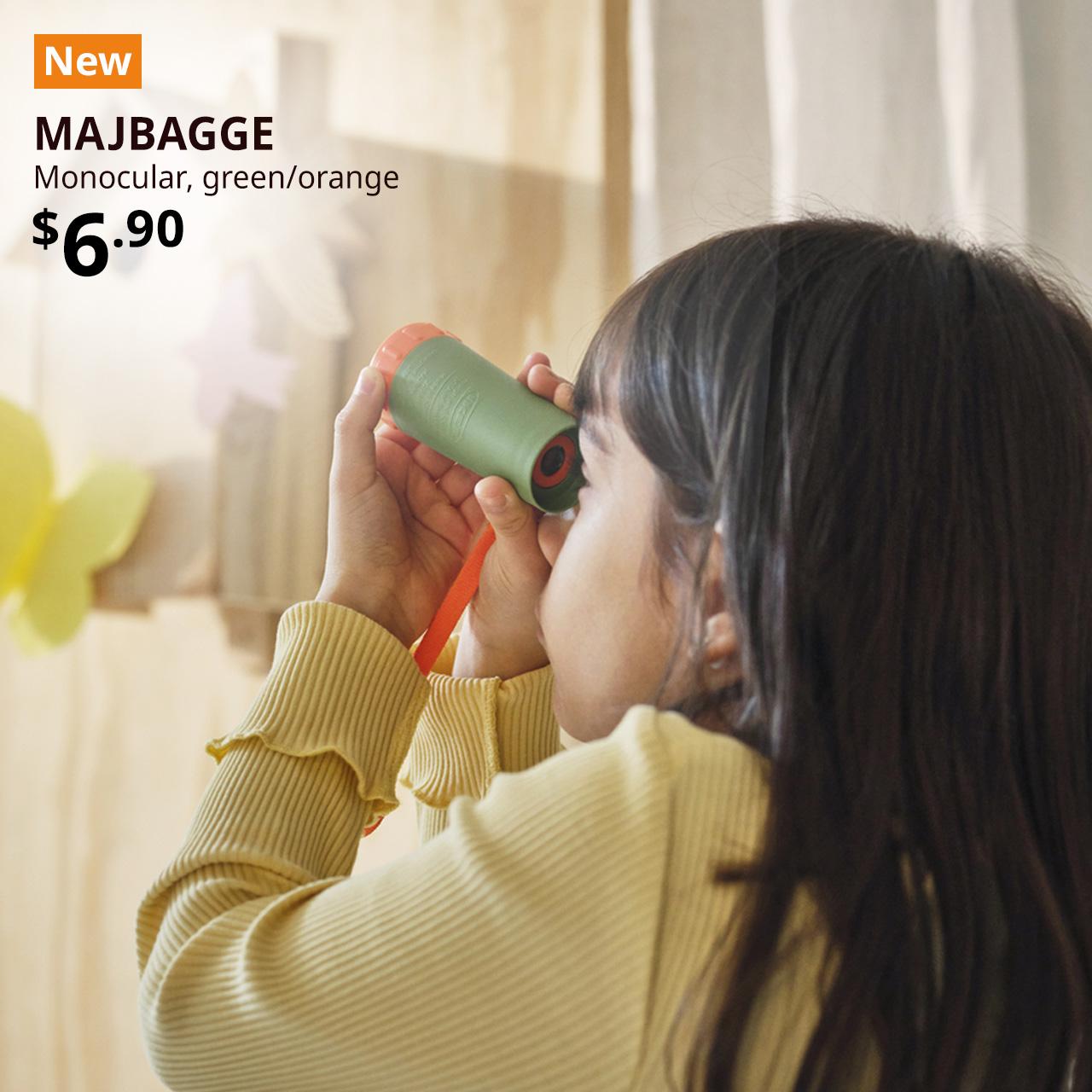 NEW tag. Child holding a green/orange MAJBAGGE monocular to her left eye and squinting. $6.90