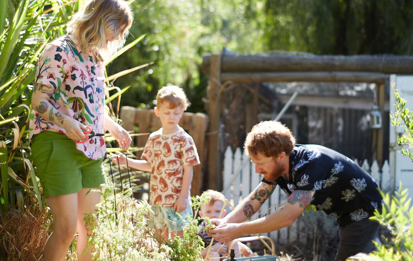 Nici, Ben és két gyermekük dolgoznak a kertben.