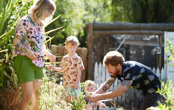 Nici, Ben és két gyermekük dolgoznak a kertben.